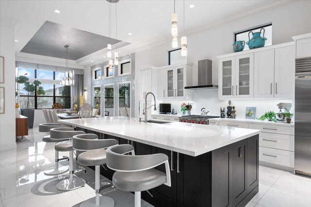 6940 NW 25th Way, Boca Raton, FL 33496 - kitchen featuring wall chimney range hood, a sink, backsplash, light marble finish floors, and crown molding