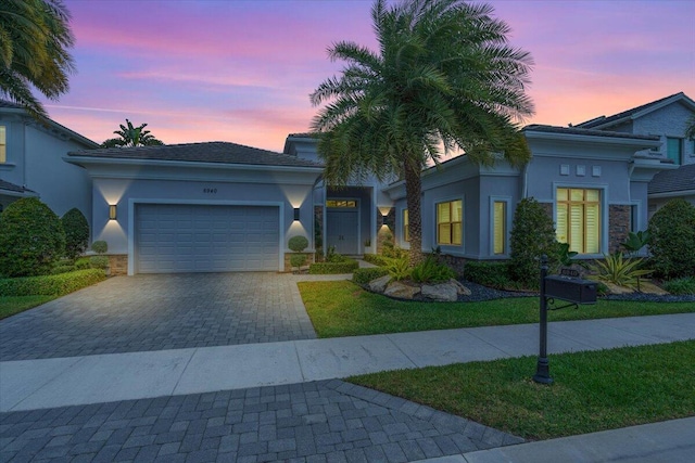 6940 NW 25th Way, Boca Raton, FL 33496 - view of front of house with driveway, a garage, stucco siding, and stone siding