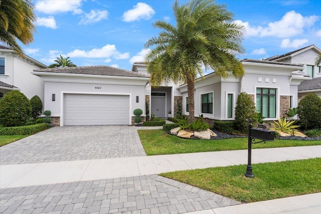 6940 NW 25th Way, Boca Raton, FL 33496 - view of front of home with decorative driveway, an attached garage, stucco siding, and stone siding