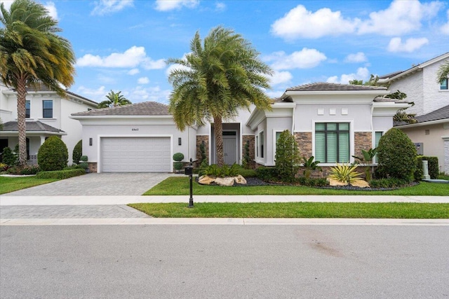 6940 NW 25th Way, Boca Raton, FL 33496 - view of front facade with stone siding, a garage, stucco siding, and decorative driveway