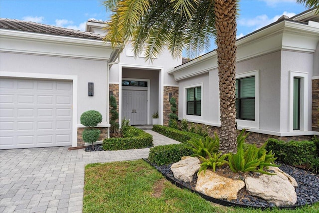 6940 NW 25th Way, Boca Raton, FL 33496 - property entrance with stone siding, stucco siding, a garage, and driveway