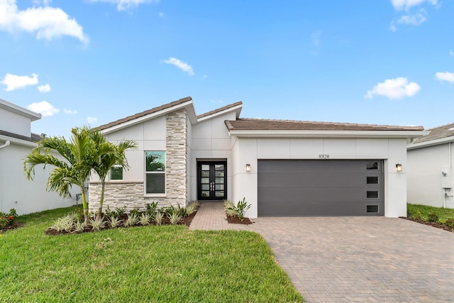 10128 SW Carnelian St, Port Saint Lucie, FL 34987 - view of front of home featuring decorative driveway, french doors, stone siding, and stucco siding