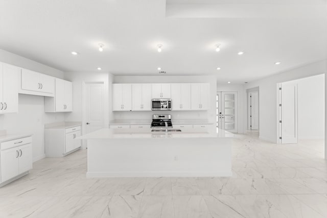 10128 SW Carnelian St, Port Saint Lucie, FL 34987 - kitchen featuring an island with sink, marble finish floor, stainless steel appliances, white cabinetry, and recessed lighting