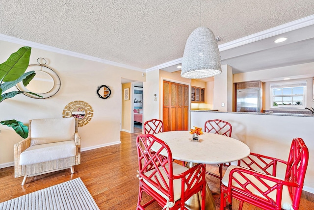 dining room featuring baseboards, ornamental molding, recessed lighting, and a textured ceiling