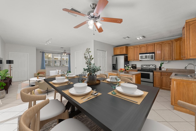 10531 NW 57th St, Coral Springs, FL 33076 - kitchen featuring appliances with stainless steel finishes, a sink, light tile patterned floors, a ceiling fan, and a kitchen island