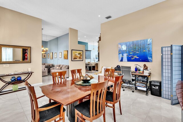 living area featuring an inviting chandelier, a high ceiling, and light tile patterned flooring