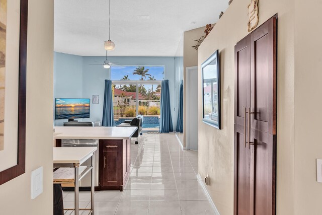 hallway with baseboards and light tile patterned floors