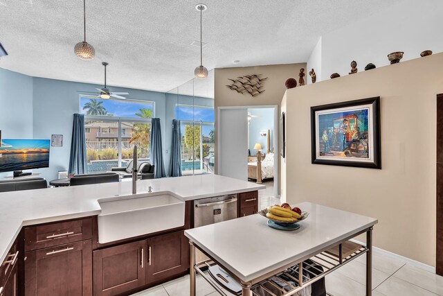 kitchen featuring light countertops, open floor plan, a sink, and dishwasher