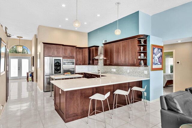 kitchen featuring recessed lighting, tasteful backsplash, wall chimney range hood, and stainless steel appliances