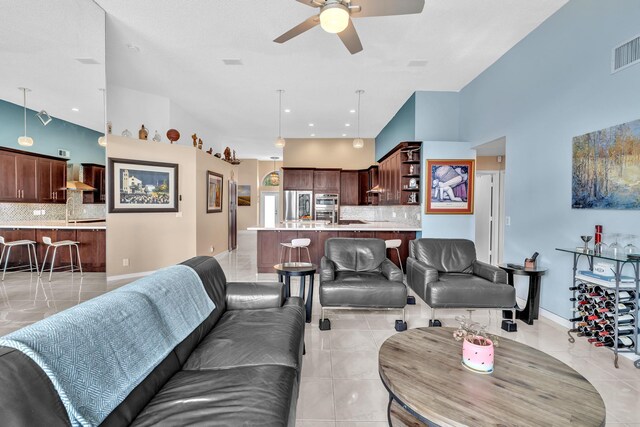 living area featuring baseboards, ceiling fan, visible vents, and light tile patterned floors