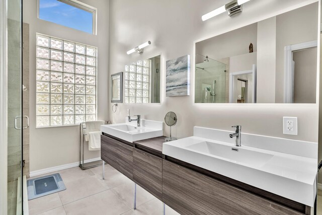 full bathroom with double vanity, tile patterned floors, a sink, and a stall shower