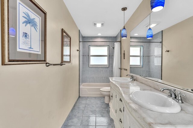 full bath featuring toilet, tile patterned floors, a sink, and shower / bath combo with shower curtain