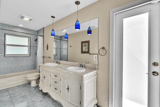 bathroom with a sink, tile patterned floors, toilet, and shower / bathtub combination with curtain