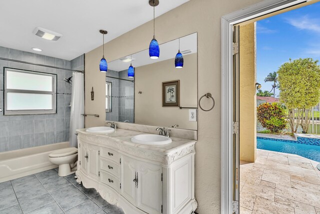 bathroom with a sink, shower / bath combo with shower curtain, toilet, and double vanity