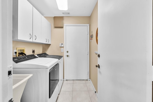 clothes washing area featuring cabinet space, washer and dryer, a sink, light tile patterned floors, and visible vents