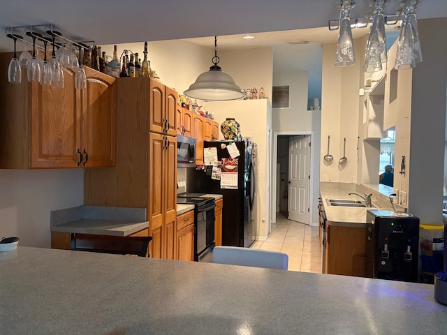 kitchen with a sink, brown cabinets, and black appliances