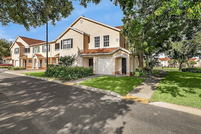townhome / multi-family property featuring a residential view, stucco siding, and a front lawn