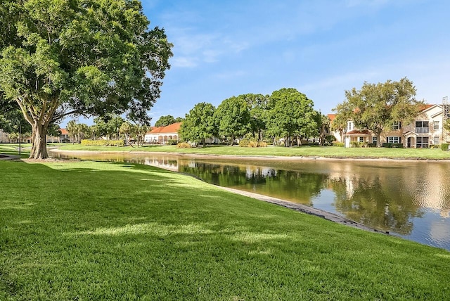 view of property's community featuring a lawn and a water view