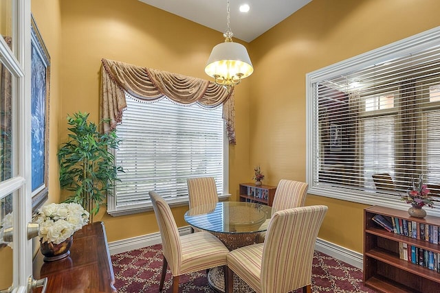 dining area featuring a healthy amount of sunlight, baseboards, and a notable chandelier