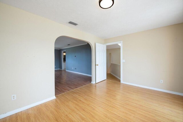 2650 SW Acco Rd, Port Saint Lucie, FL 34953 - spare room featuring baseboards, arched walkways, light wood finished floors, and visible vents