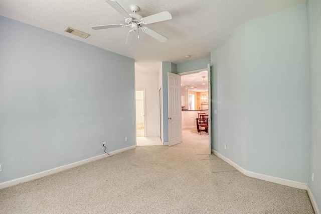 606 SW Treasure Cv, Port Saint Lucie, FL 34986 - unfurnished room featuring light carpet, a ceiling fan, baseboards, and a textured ceiling