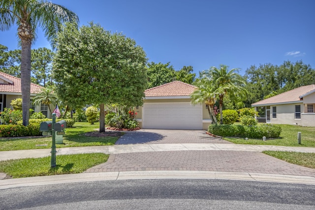 606 SW Treasure Cv, Port Saint Lucie, FL 34986 - mediterranean / spanish home featuring driveway, an attached garage, stucco siding, and a front lawn