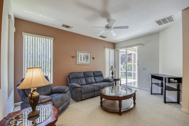 606 SW Treasure Cv, Port Saint Lucie, FL 34986 - carpeted living area with ceiling fan, baseboards, and a textured ceiling