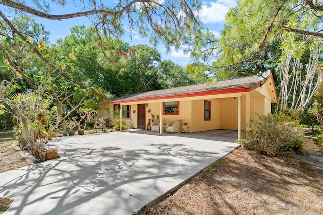 single story home featuring concrete driveway and an attached carport