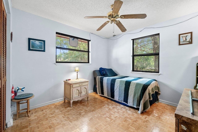 bedroom with baseboards, a textured ceiling, and ceiling fan