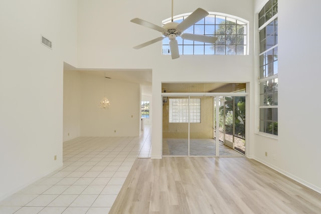 17288 Shoals Dr, Jupiter, FL 33477 - unfurnished living room with a high ceiling, wood finished floors, a ceiling fan, and a chandelier