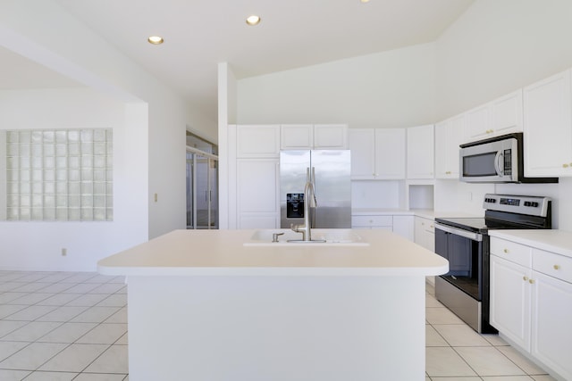 17288 Shoals Dr, Jupiter, FL 33477 - kitchen with stainless steel appliances, an island with sink, light tile patterned flooring, white cabinets, and light countertops