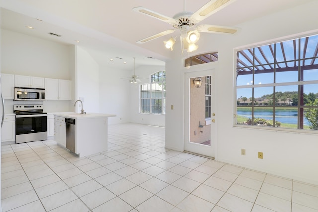 17288 Shoals Dr, Jupiter, FL 33477 - kitchen with stainless steel appliances, a ceiling fan, light countertops, open floor plan, and white cabinets