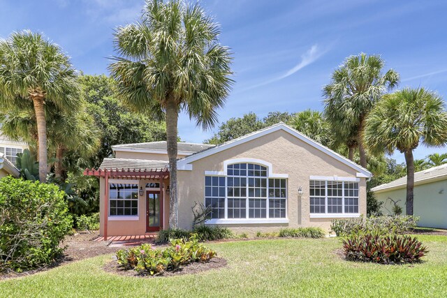 17288 Shoals Dr, Jupiter, FL 33477 - rear view of property featuring stucco siding and a lawn
