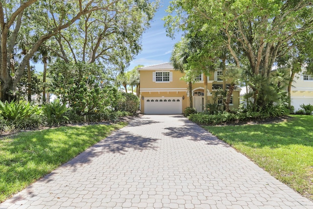 17288 Shoals Dr, Jupiter, FL 33477 - view of front facade with a garage, decorative driveway, stucco siding, and a front yard