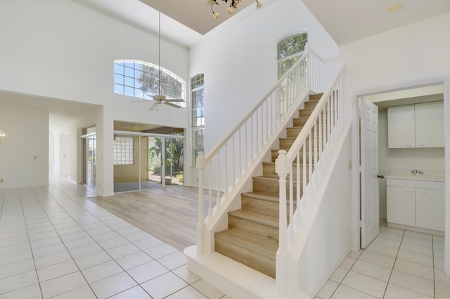 17288 Shoals Dr, Jupiter, FL 33477 - stairway with plenty of natural light, a ceiling fan, a high ceiling, and tile patterned flooring