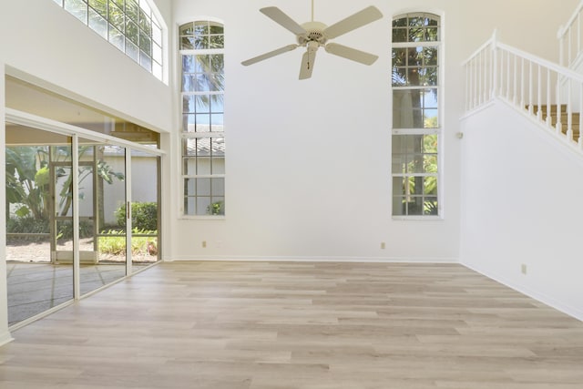 17288 Shoals Dr, Jupiter, FL 33477 - empty room with a high ceiling, a ceiling fan, wood finished floors, and stairway