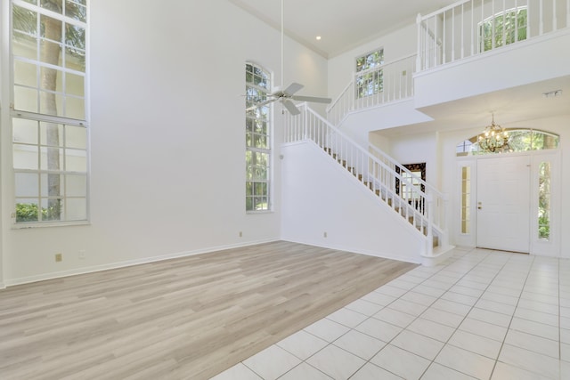 17288 Shoals Dr, Jupiter, FL 33477 - entrance foyer featuring stairs, a high ceiling, healthy amount of natural light, wood finished floors, and a chandelier