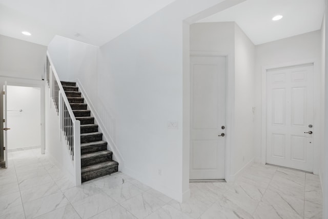 staircase featuring baseboards, recessed lighting, and marble finish floor