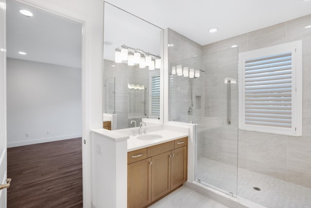 bathroom with vanity, recessed lighting, wood finished floors, and a stall shower