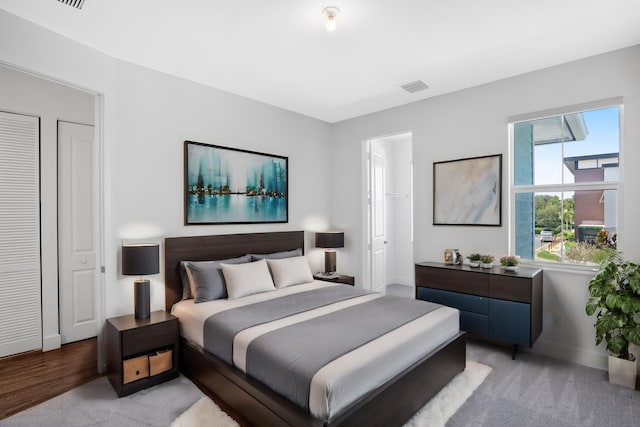 bedroom featuring baseboards, visible vents, and light carpet