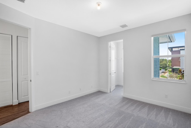 unfurnished bedroom with visible vents, baseboards, a closet, a spacious closet, and carpet