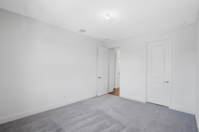 unfurnished bedroom featuring carpet floors, baseboards, and visible vents