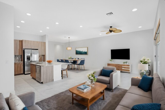 living room with visible vents, recessed lighting, marble finish floor, and a ceiling fan