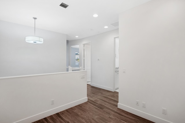 unfurnished room with visible vents, recessed lighting, baseboards, and dark wood-style flooring
