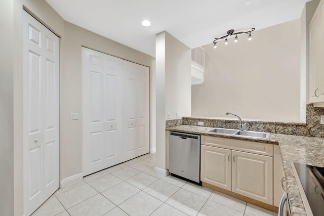 kitchen featuring range, dishwasher, a sink, baseboards, and light tile patterned flooring