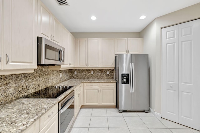 kitchen featuring visible vents, tasteful backsplash, light tile patterned floors, light stone counters, and stainless steel appliances