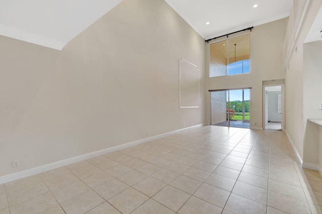 unfurnished room featuring recessed lighting, baseboards, light tile patterned floors, and a high ceiling