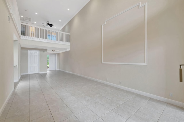 unfurnished living room with ceiling fan, a high ceiling, recessed lighting, baseboards, and light tile patterned floors