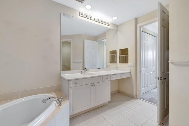 full bath featuring a garden tub, tile patterned flooring, and vanity