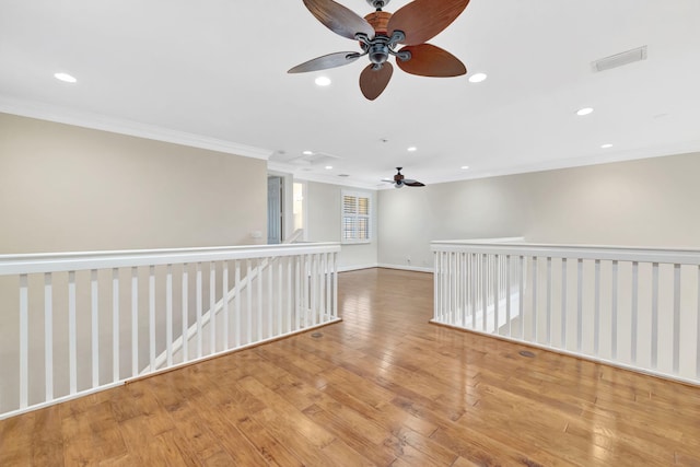 unfurnished room with a ceiling fan, visible vents, crown molding, wood finished floors, and recessed lighting